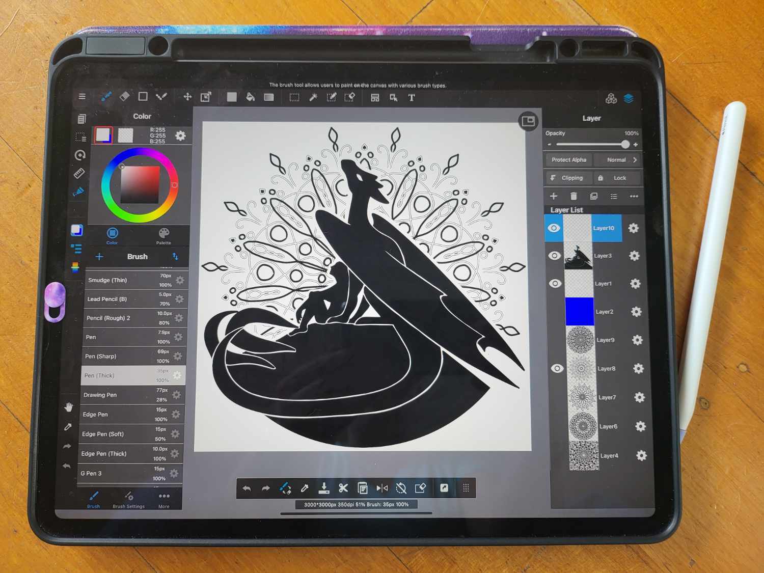 An iPad with Apple Pencil showing the digital file of one of the dragon designs in black and white.