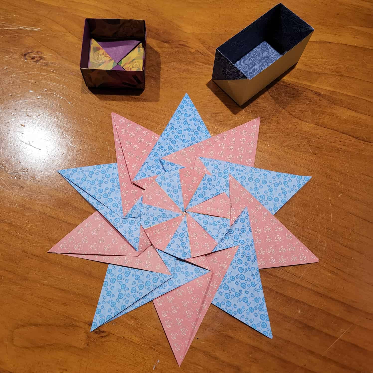 The reverse side of the modular origami star shows the paper is floral on the reverse side, alternating orange and blue. The boxes are also turned over to show the inside.
