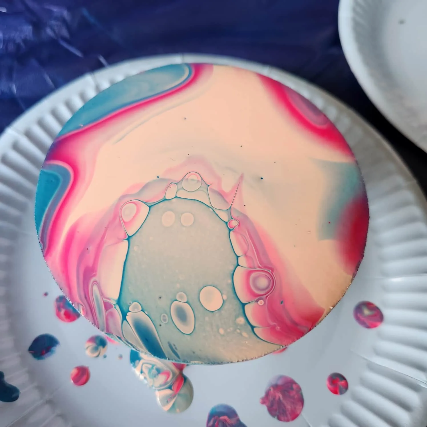 Coaster with an off-white, pink, and blue design.