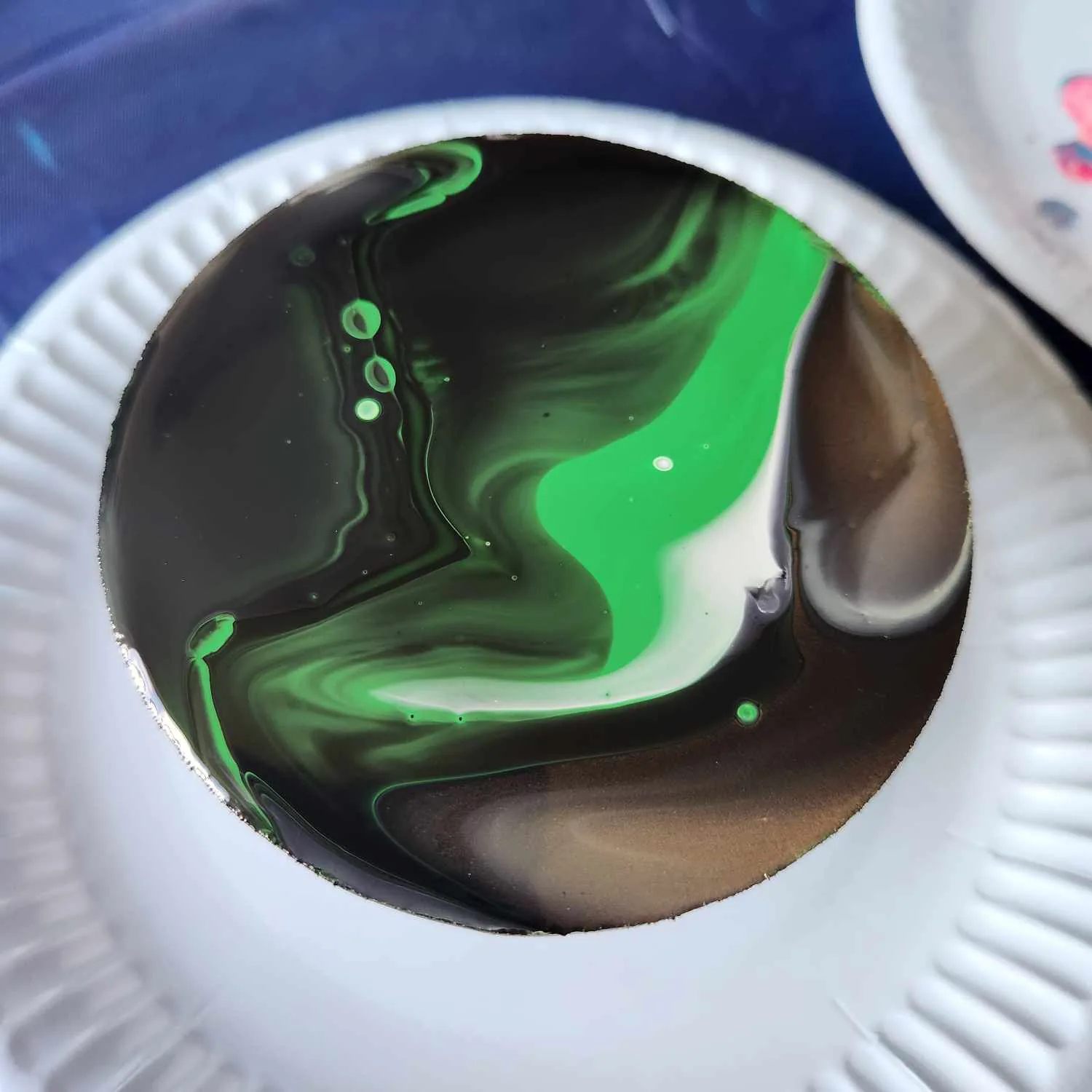 Coaster with a marbled black, green and white design.