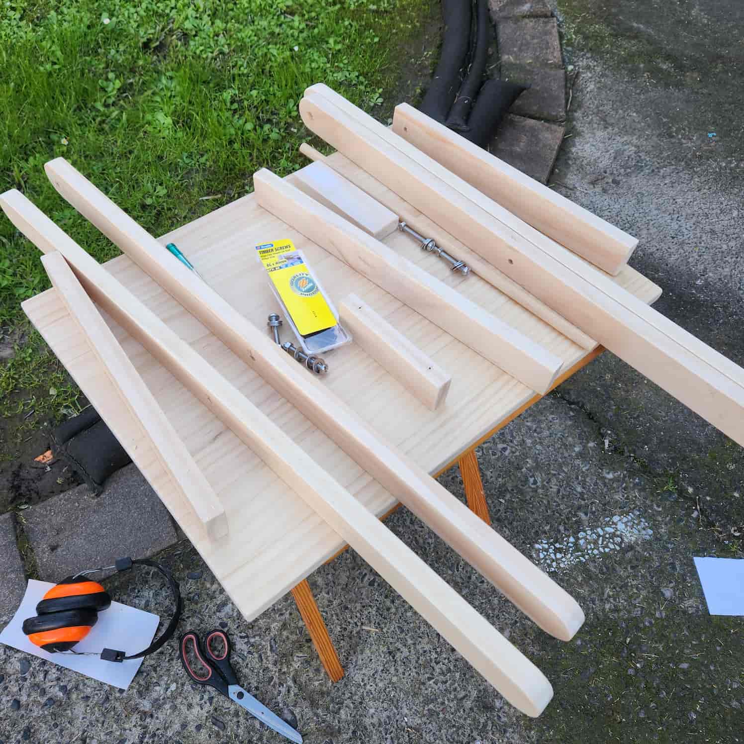 All of the cut and prepared pieces of wood ready to be assembled. These are perched on another folding table, the one used as the template.