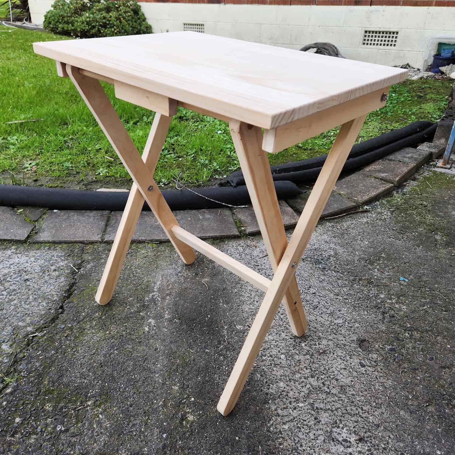 The fully assembled folding table, not yet stained (raw wood surface).