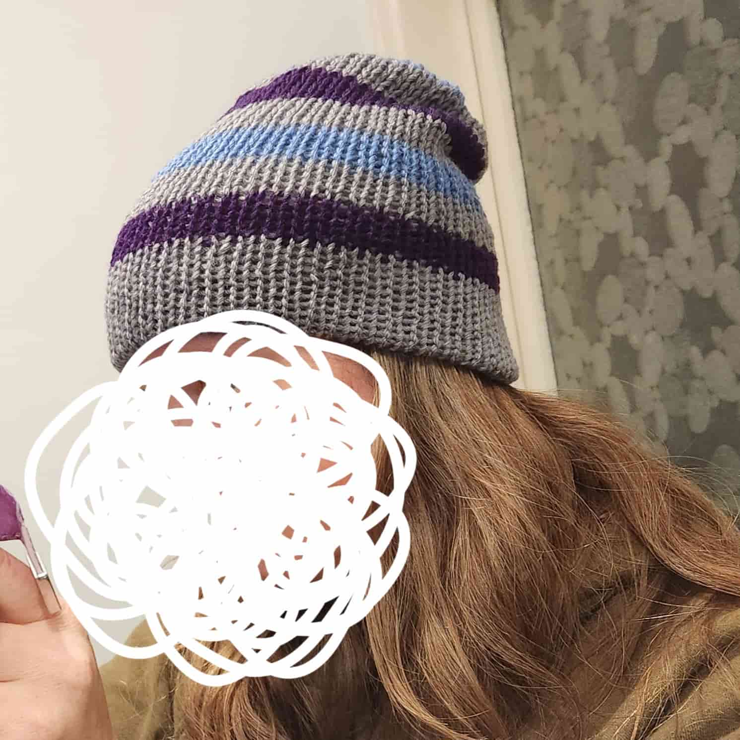 A grey beanie with dark purple and light blue stripes.