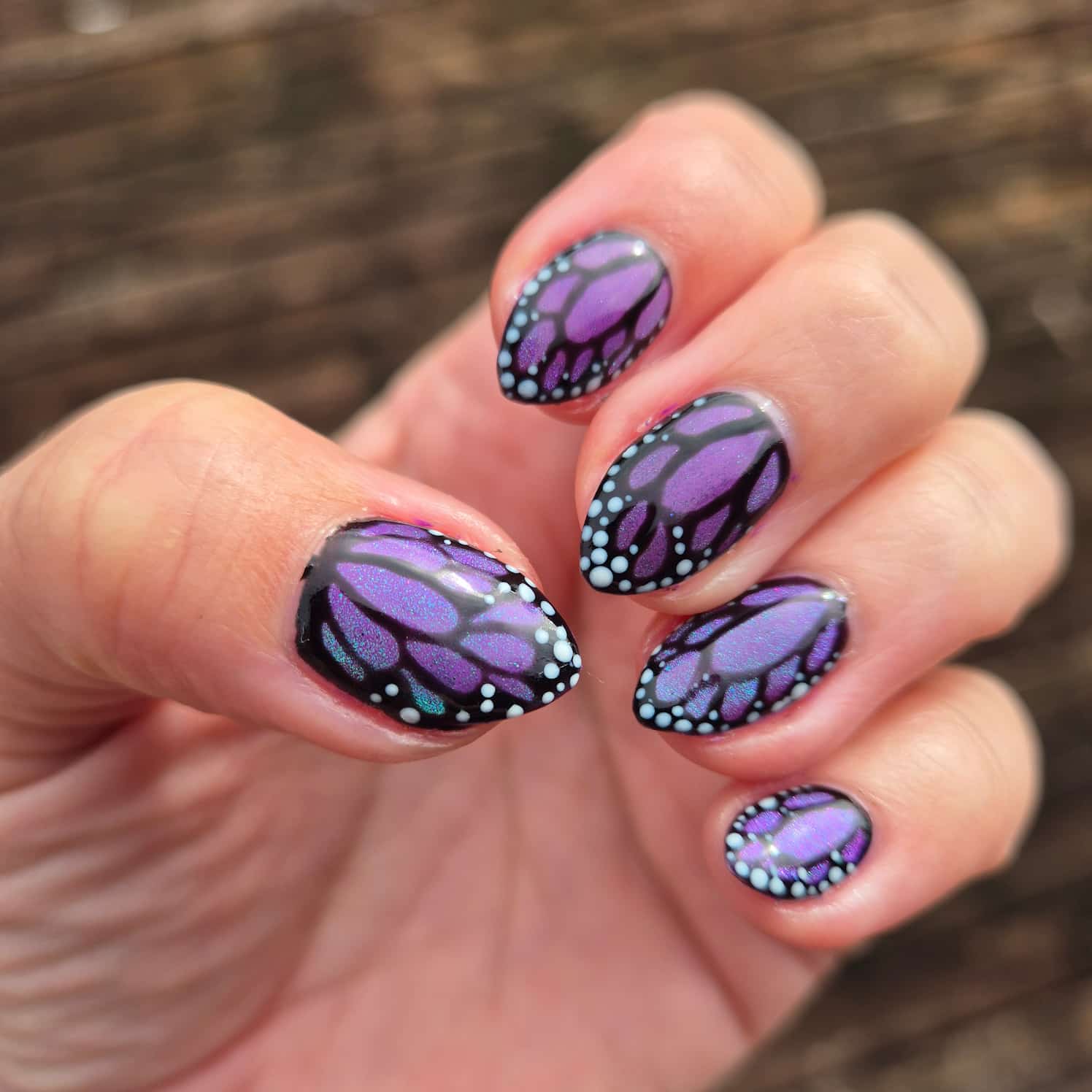 Subtle shimmery purple butterfly nail design.