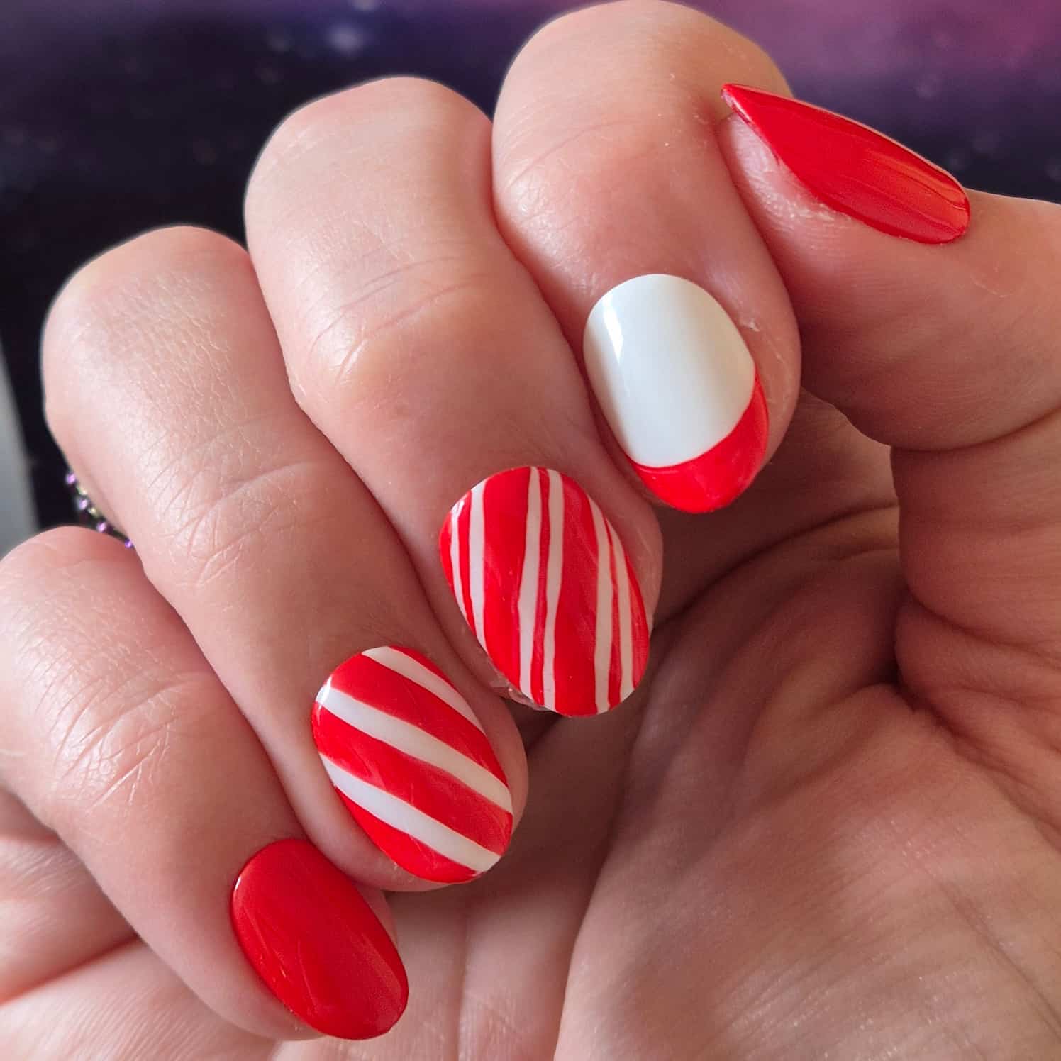 Red and white striped candy-cane nail design.